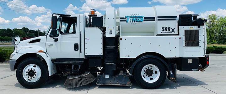 2006 TYMCO 500X Sweeper (#004146): Mounted on an International 4200 Chassis. Two Gutter Brooms - Drop Down and Hi/Low Pressure Wash Down. Act Now On This One! Driver side profile view.