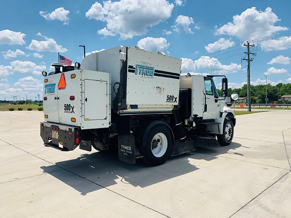 2006 TYMCO 500X Sweeper (#004146): Mounted on an International 4200 Chassis. Two Gutter Brooms - Drop Down and Hi/Low Pressure Wash Down. Act Now On This One! Passenger side rear 3/4 view.