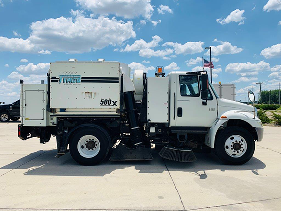 2006 TYMCO 500X Sweeper (#004146): Mounted on an International 4200 Chassis. Two Gutter Brooms - Drop Down and Hi/Low Pressure Wash Down. Act Now On This One! Passenger side profile view.