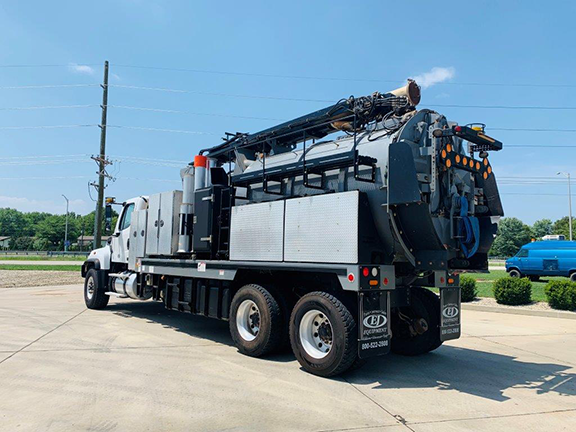 2015 Vac-Con Hydroexcavator (#006953), Mounted on a Freightliner 114SD 6x4 66000GVWR ISL370 3000RDS. A 20 gpm / 4000psi Water System, hydraulically driven. 8’ x 8” Rear Mounted Telescoping Power Flex Boom with Pendant Control Station. Includes 12-yard Debris Tank and PD Blower. Driver side rear 3/4 view.